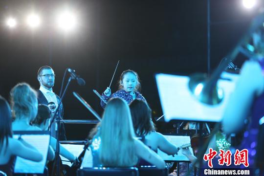 圖為音樂會現(xiàn)場樂團指揮邀請現(xiàn)場觀眾上臺體驗。　張海雯 攝