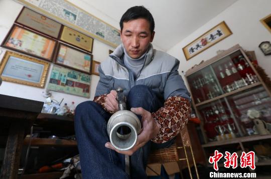 馬華強對基本成型的錫壺壺身敲打修整�！↑S水林 攝