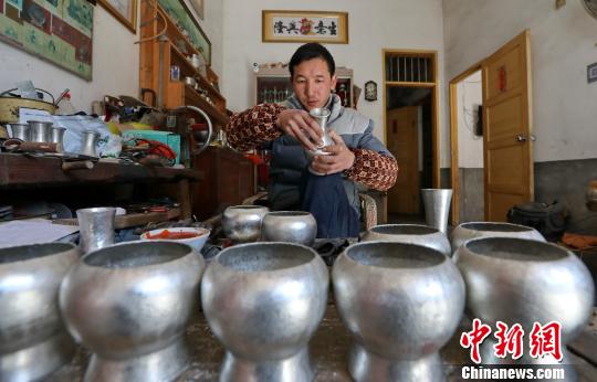 馬華強對錫壺部件進(jìn)行拼接 黃水林 攝