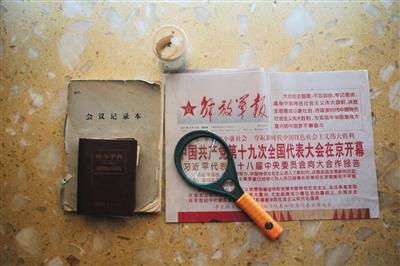 周智夫生前看的報紙、使用的放大鏡、字典和筆記本。