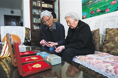周智夫二女兒周衛(wèi)平和母親婁淑珍靜靜地端詳著周智夫生前所獲勛章。